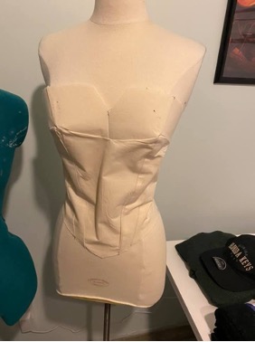 Muslin wrapped around a dress form to pattern out the undergarments